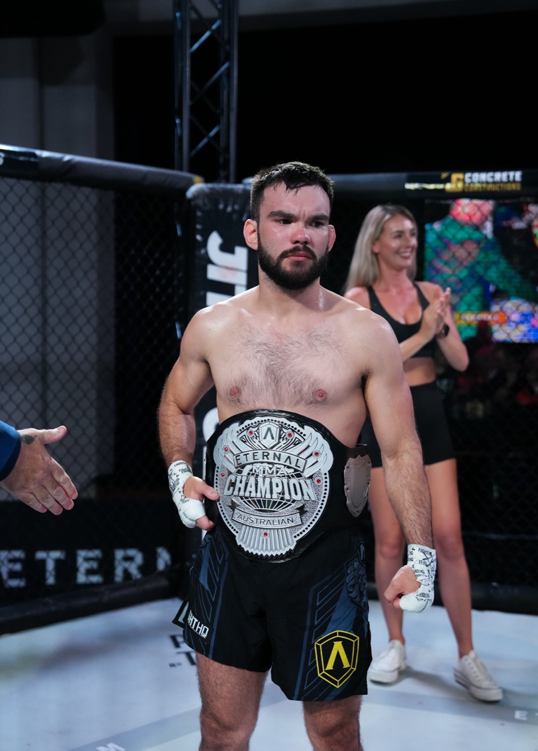 Anthony Drilich holding his Eternal MMA championship belts