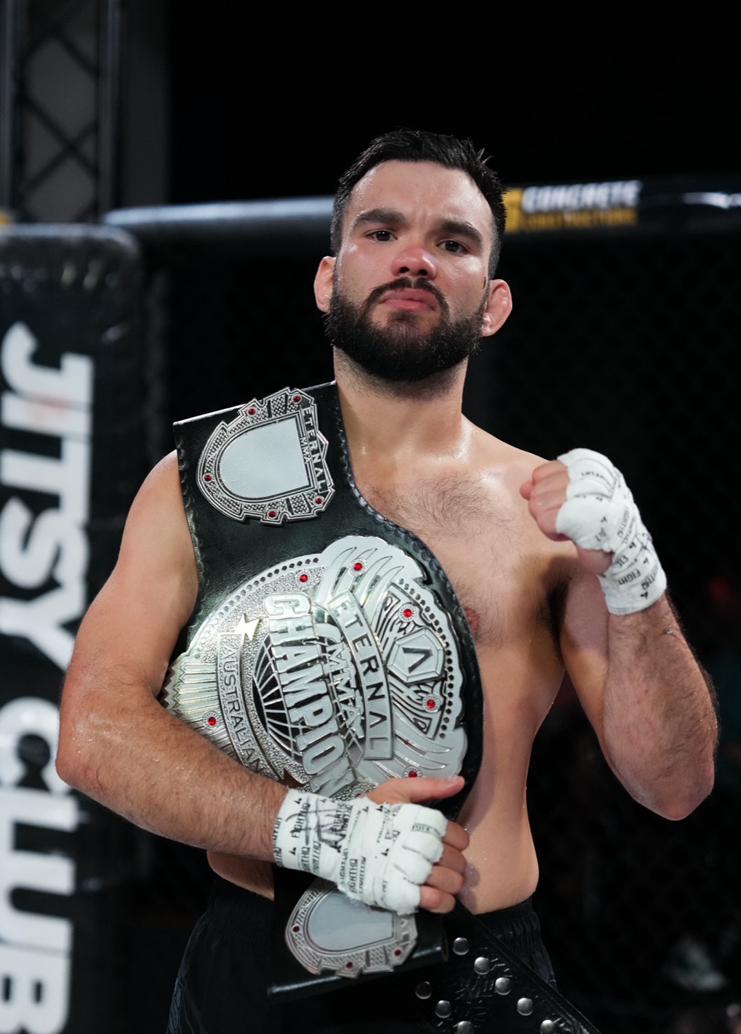 Anthony Drilich holding his Eternal MMA championship belts