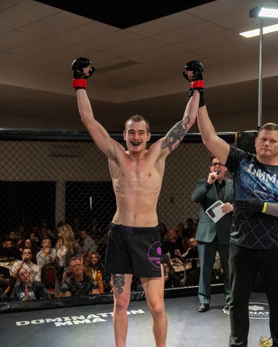 A DCA member has his hand raised by the referee after winning an MMA fight