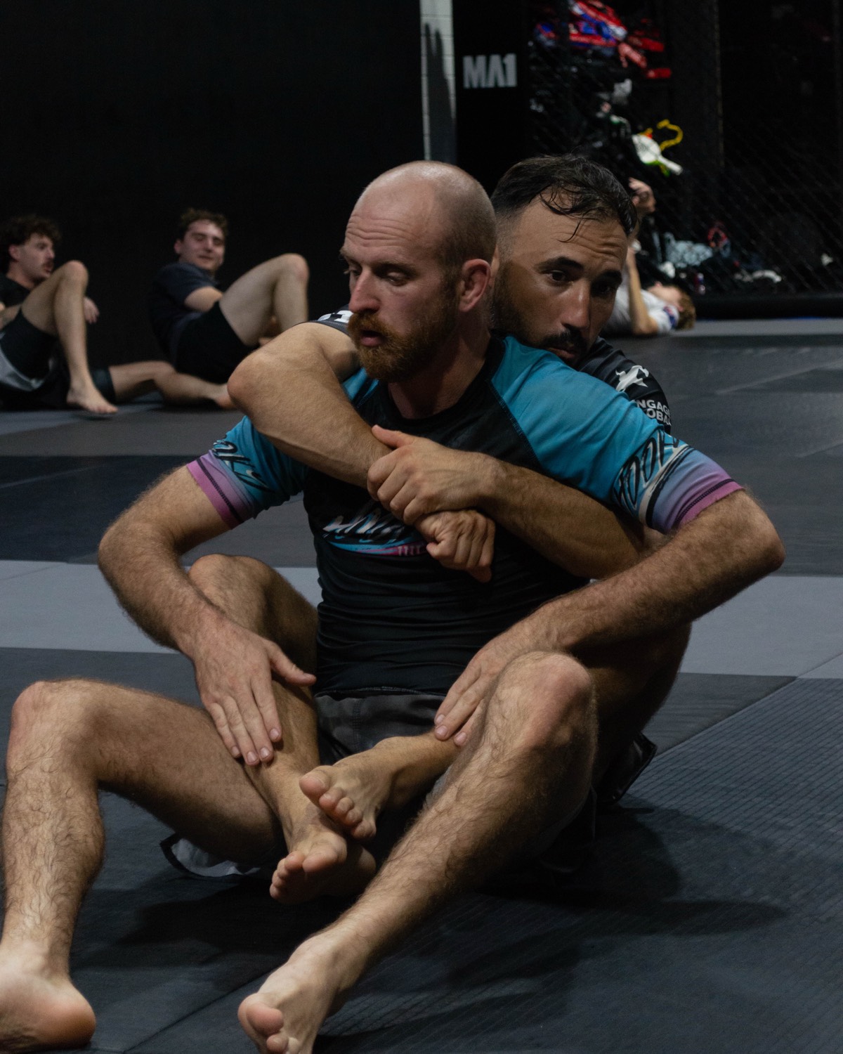 Two members drilling an armbar in a BJJ class