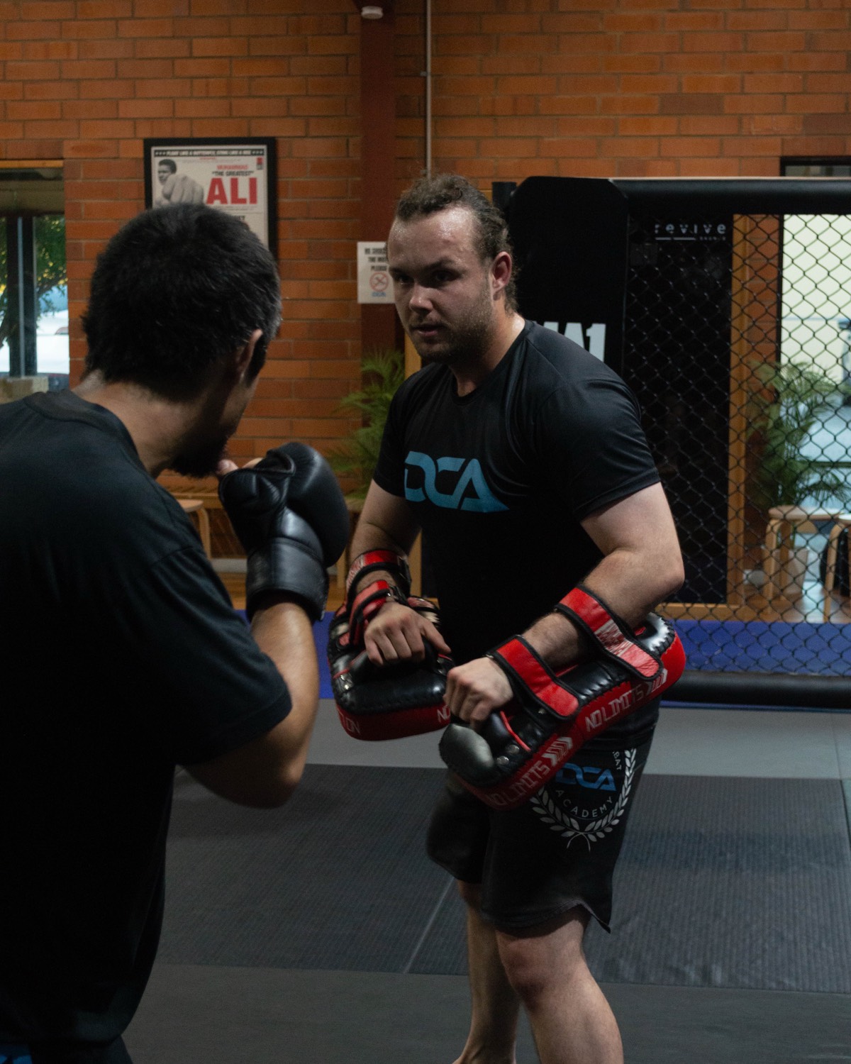 Two members working takedowns in an MMA class
