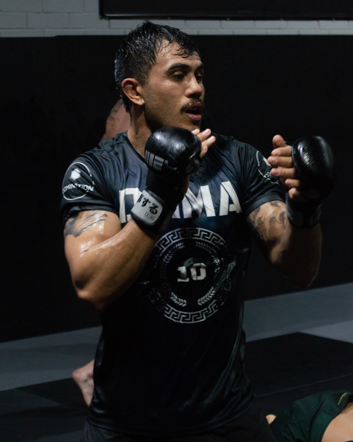 A coach demonstrating technique in an MMA class